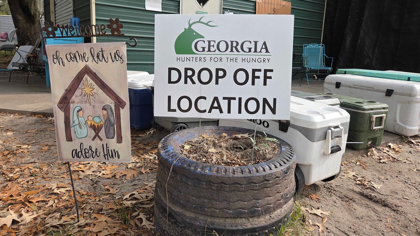 A tire and a sign indicating a drop off location for a rural hunger program