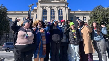 A group of people standing outside of the Georgia State Capitol.