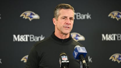 A man stands in front of several microphones at a news conference