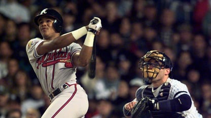 Andruw Jones hits a ball with a bat at a baseball game