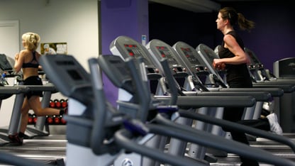 People exercise on treadmills and cardio machines in a gym