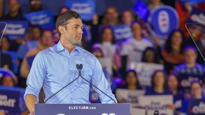 Jon Ossoff stands at a podium at a rally