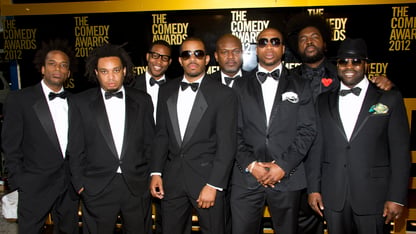The Roots band members dressed up in tuxedos pose at an event