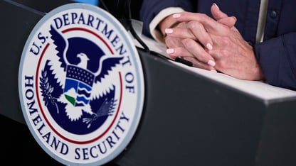 A woman's hands are shown on top of a podium that says department of homeland security