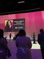 Adriane V. Jefferson speaks at a podium as her name and title appear on a screen behind her.