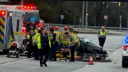An ambulance and first responders on the scene of a wreck.