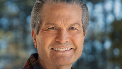 Headshot of Rick Jackson standing outside in front of some trees