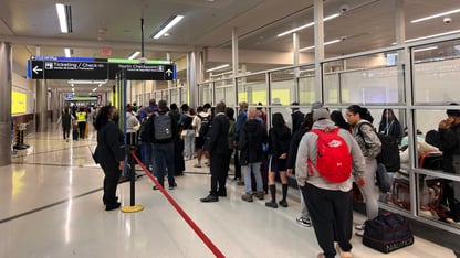 Passengers line up to go through airport security