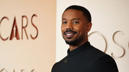 Michael B. Jordan stands on the red carpet at the Oscars in a black outfit