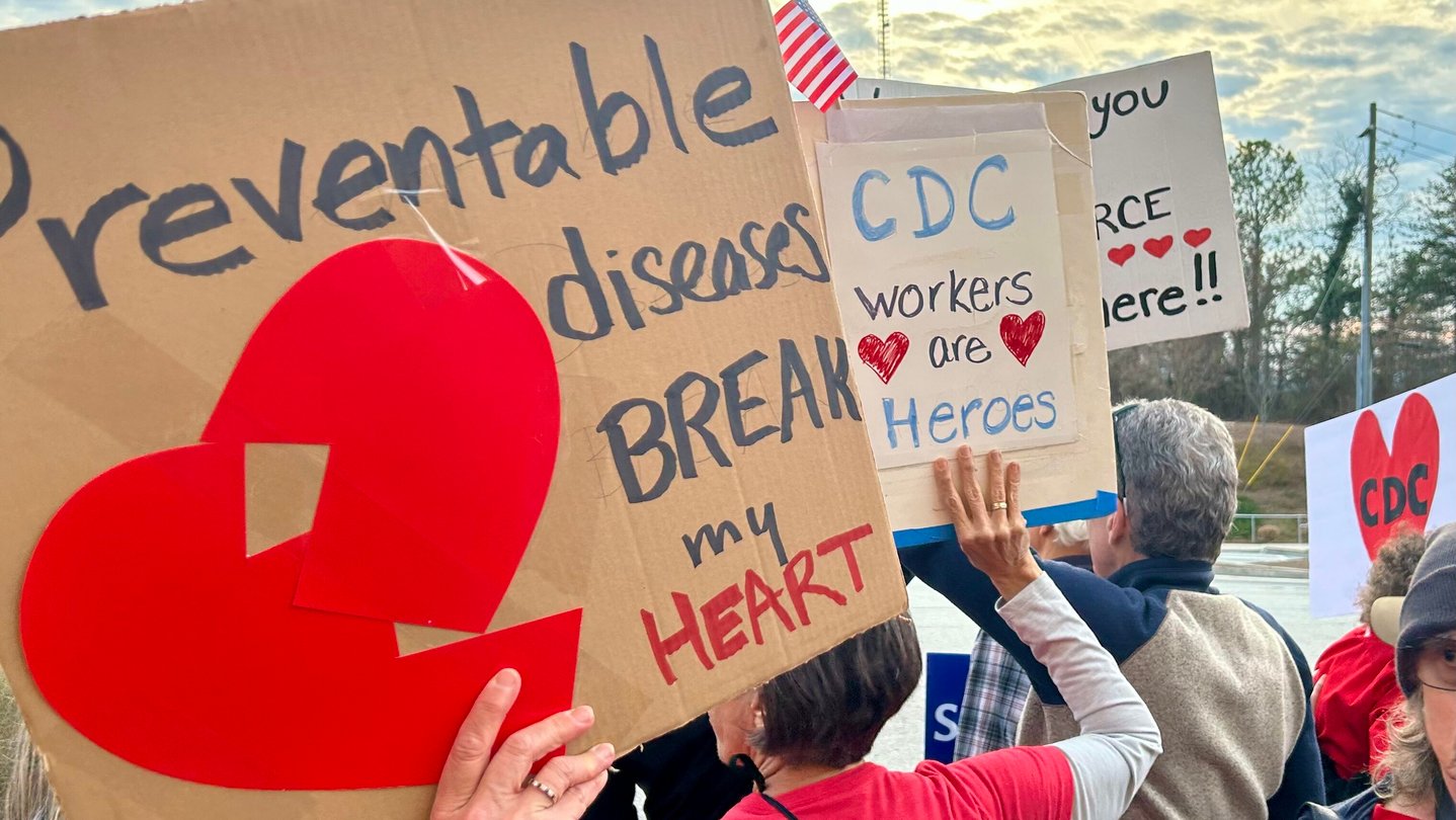 Dozens of protesters recently rallied across the street from Atlanta's CDC headquarters, marking a year since the Trump administration started mass firings at the CDC. (WABE/Jess Mador)