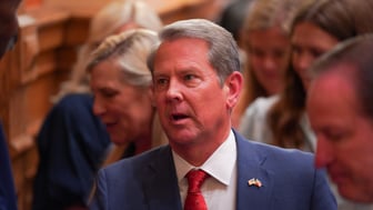 Brian Kemp looks upward while in a crowd of people