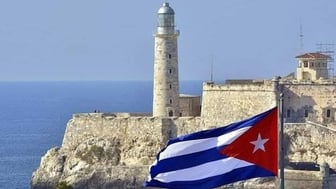 A Cuban flag waves in front of Faro Castillo del Morro in Havana.