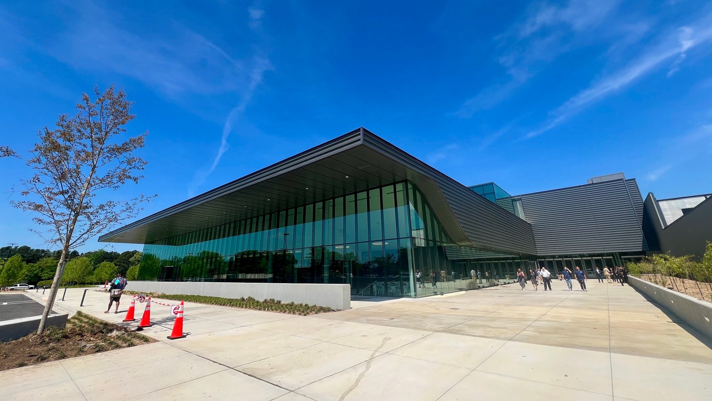 A large arena with large windows underneath a blue sky