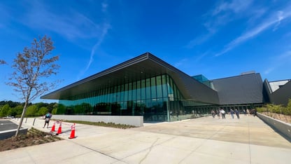 A large arena with large windows underneath a blue sky