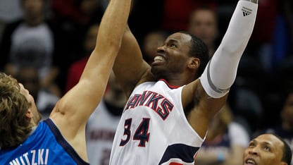 A basketball player raises his hands as he attempts to shoot