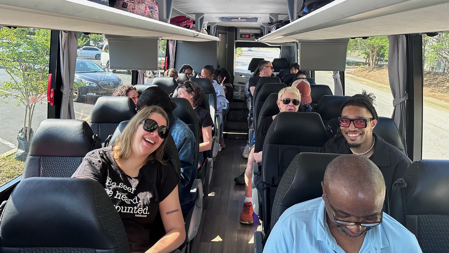 A group of people ride a coach bus