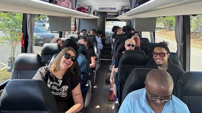 A group of people ride a coach bus