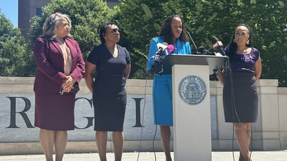 DeKalb District Attorney Sherry Boston is joined by Cobb County District Attorney Sonay Allen, Clayton County District Attorney Tasha Mosley and Fulton County District Attorney Fani Willis stand at a lectern in Atlanta’s Liberty Plaza.