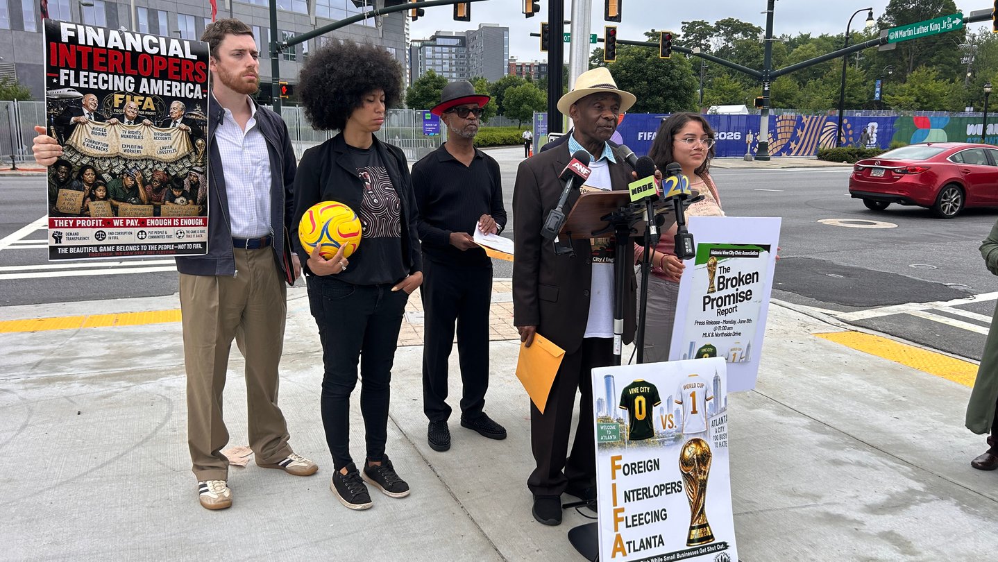 A group of people holding a press conference outside.