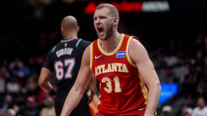 A basketball player with a red Atlanta Hawks jersey yells in celebration