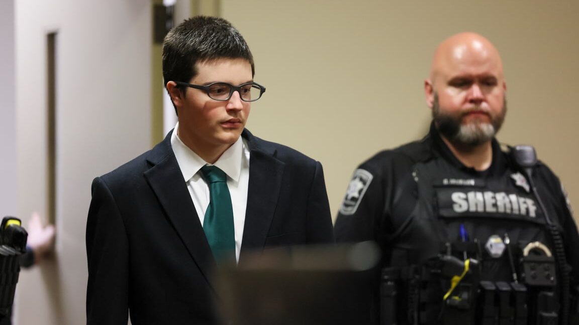 Colt Gray is seen wearing a suit and green tie in court.