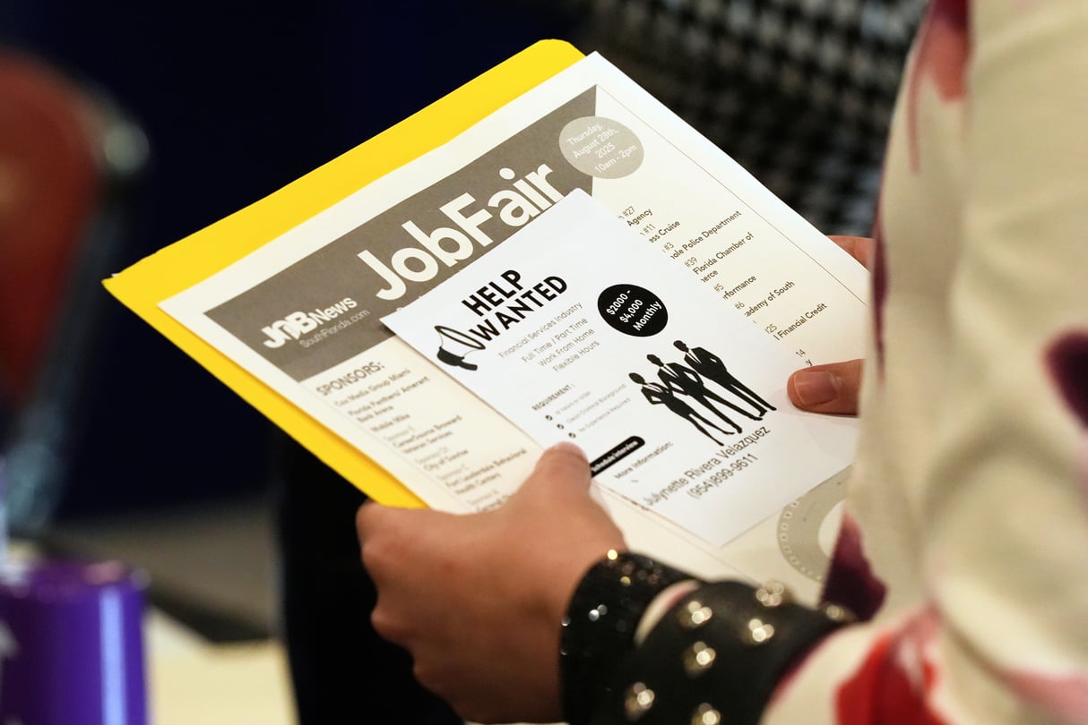 A person holds a folder and sheets of paper