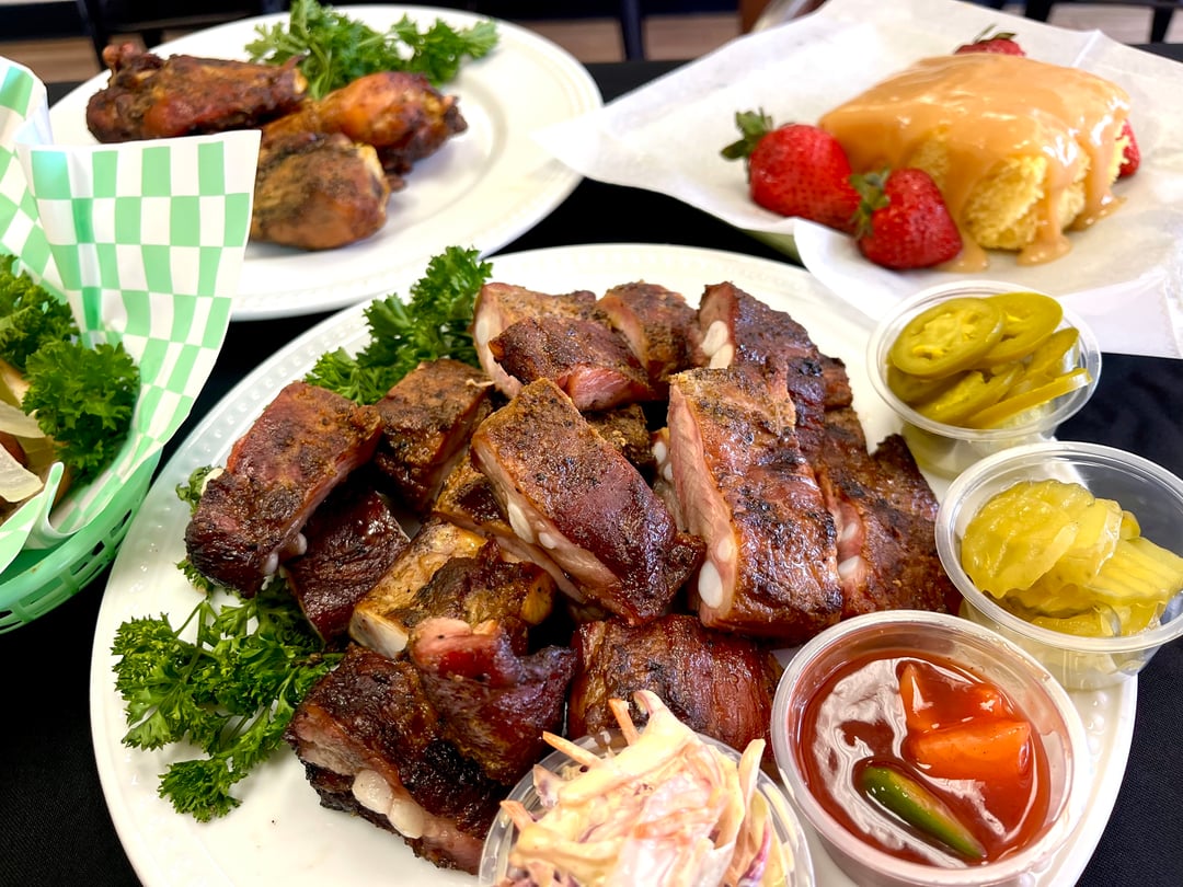 An assortment of food is shown on several different plates and in a basket
