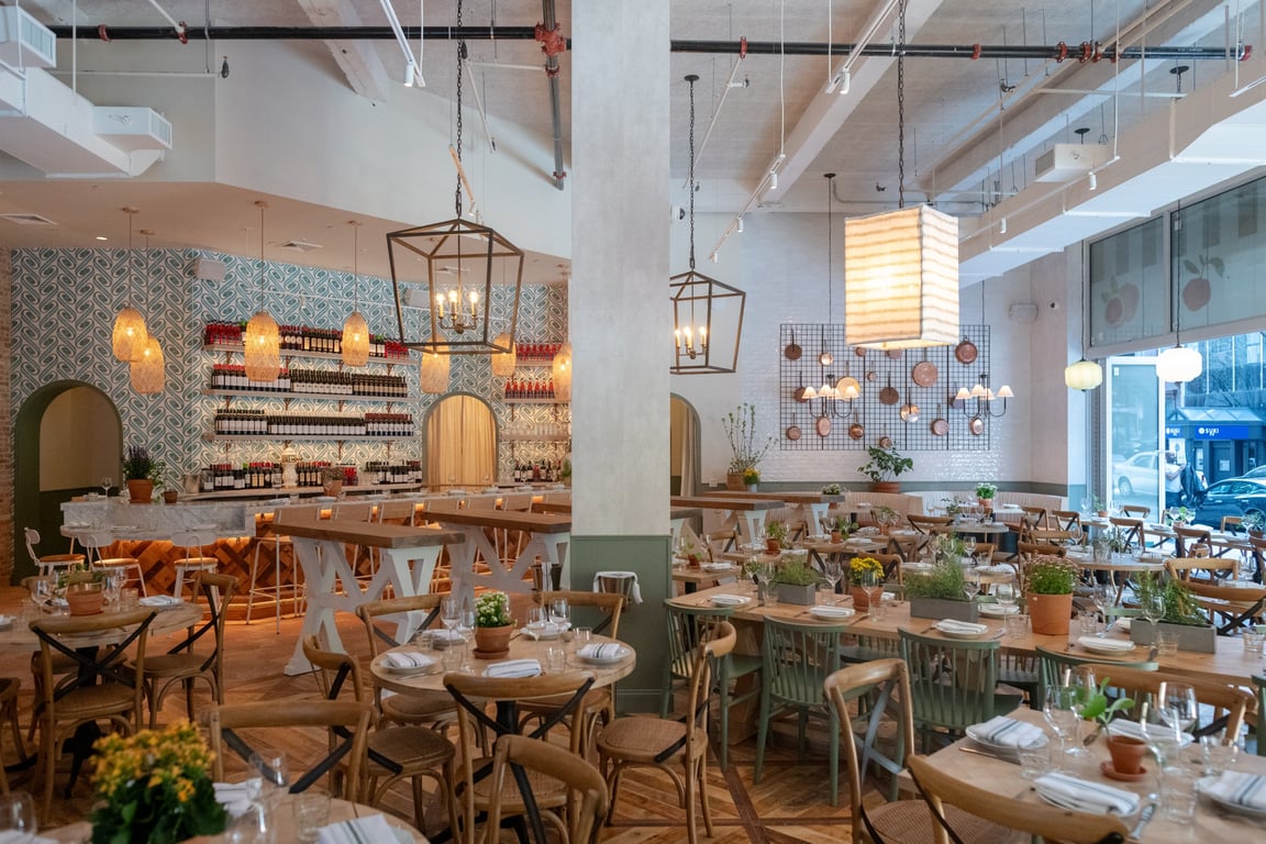This Popular NYC Italian Restaurant Adds a Laid-Back Flair to Midtown Manhattan | Rosemary's Midtown interior seating | Rosemary's Midtown table with food | Rosemary's Midtown appetizers | Rosemary's Midtown signature salad | Rosemary's Midtown pasta in sauce | Rosemary's Midtown dessert cake slice