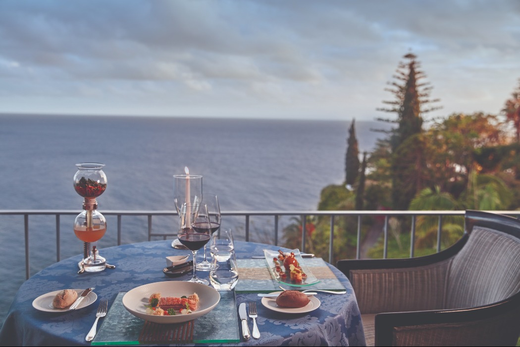 Reid's Palace, a Belmond Hotel restraunt view | Reid's Palace, a Belmond Hotel aerial hotel view | Reid's Palace, a Belmond Hotel balcony | Reid's Palace, a Belmond Hotel bedroom | Reid's Palace, a Belmond Hotel aerial view | Reid's Palace, a Belmond Hotel ocean view | Reid's Palace, a Belmond Hotel outdoor dining | Reid's Palace, a Belmond Hotel restaurant | This Luxe and Historical Hotel Is Located on a Portuguese Island Dubbed “The Hawaii of Europe”