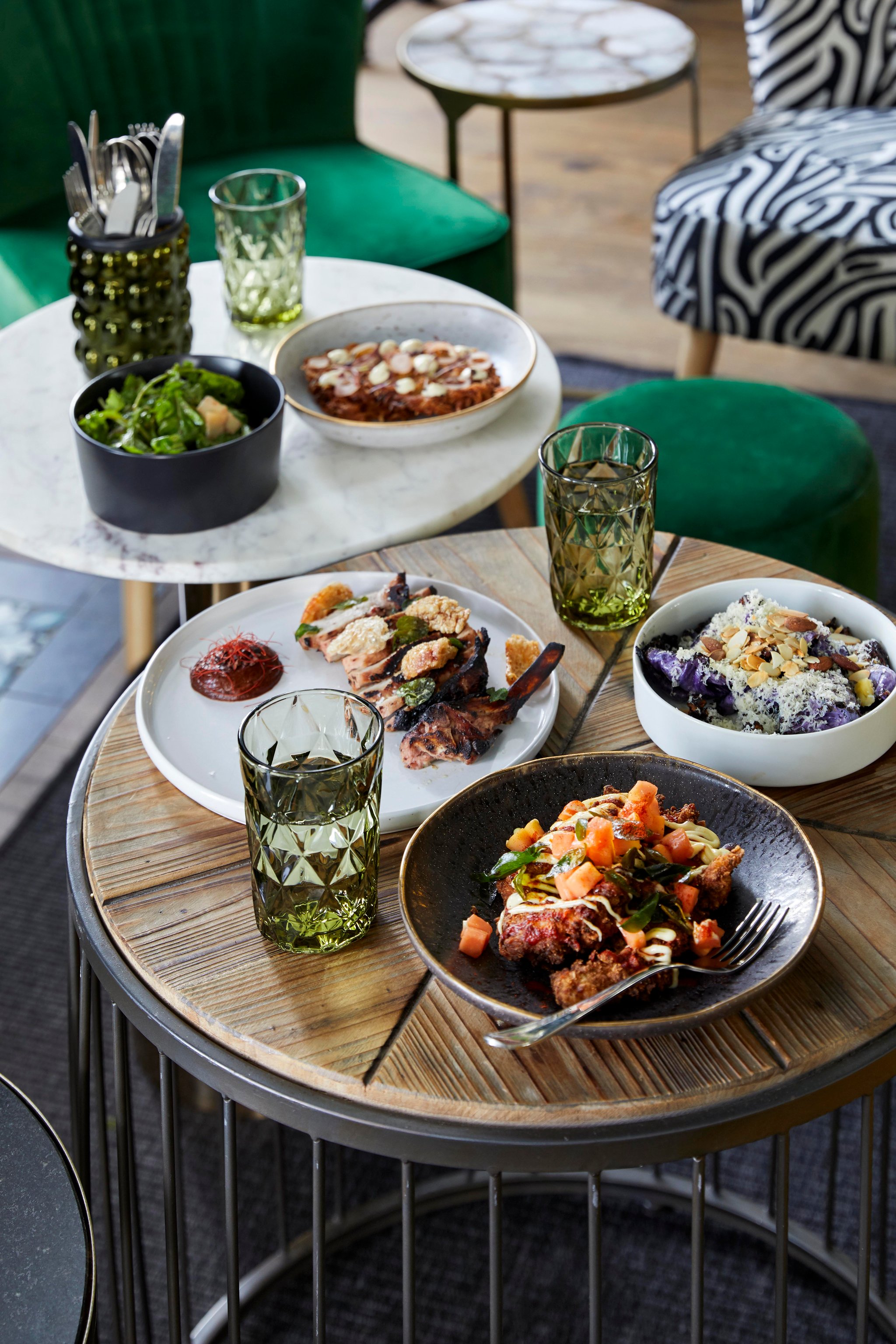 Shared plates and green glassware at Upper Union restaurant, Cape Cadogan.