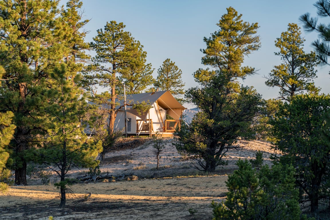This Is the Best Off-the-Grid Glamping Experience in Bryce Canyon National Park | Under Canvas Bryce Canyon Southern Utah | Under Canvas Bryce Canyon tent area | Under Canvas Bryce Canyon bed in tent | Under Canvas Bryce Canyon tent steps | Under Canvas Bryce Canyon tent seating | Under Canvas Bryce Canyon evening | Under Canvas Bryce Canyon nighttime