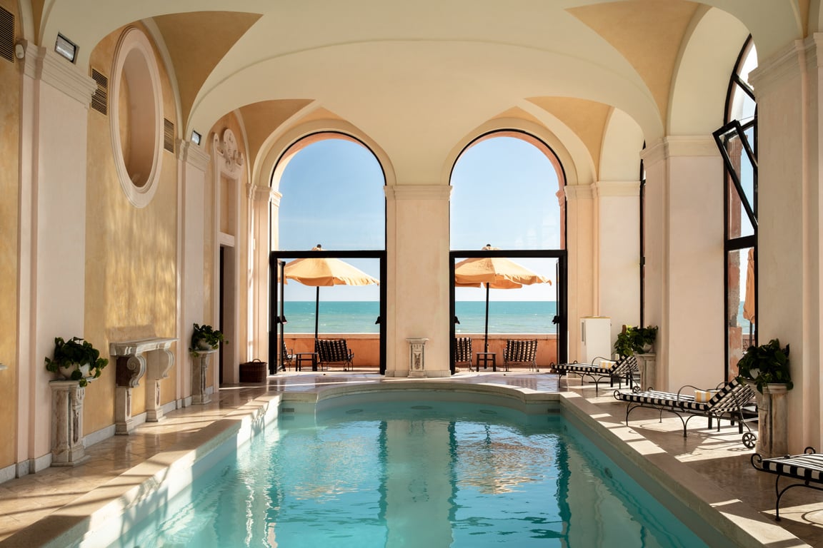 La Posta Vecchia Is Italy’s Hidden Gem Hotel along the Tyrrhenian Sea | La Posta Vecchia bedroom and decor | La Posta Vecchia indoor pool | La Posta Vecchia suite hot tub | La Posta Vecchia bedroom suite | La Posta Vecchia restaurant seating | La Posta Vecchia outdoor cabanas | La Posta Vecchia lobby