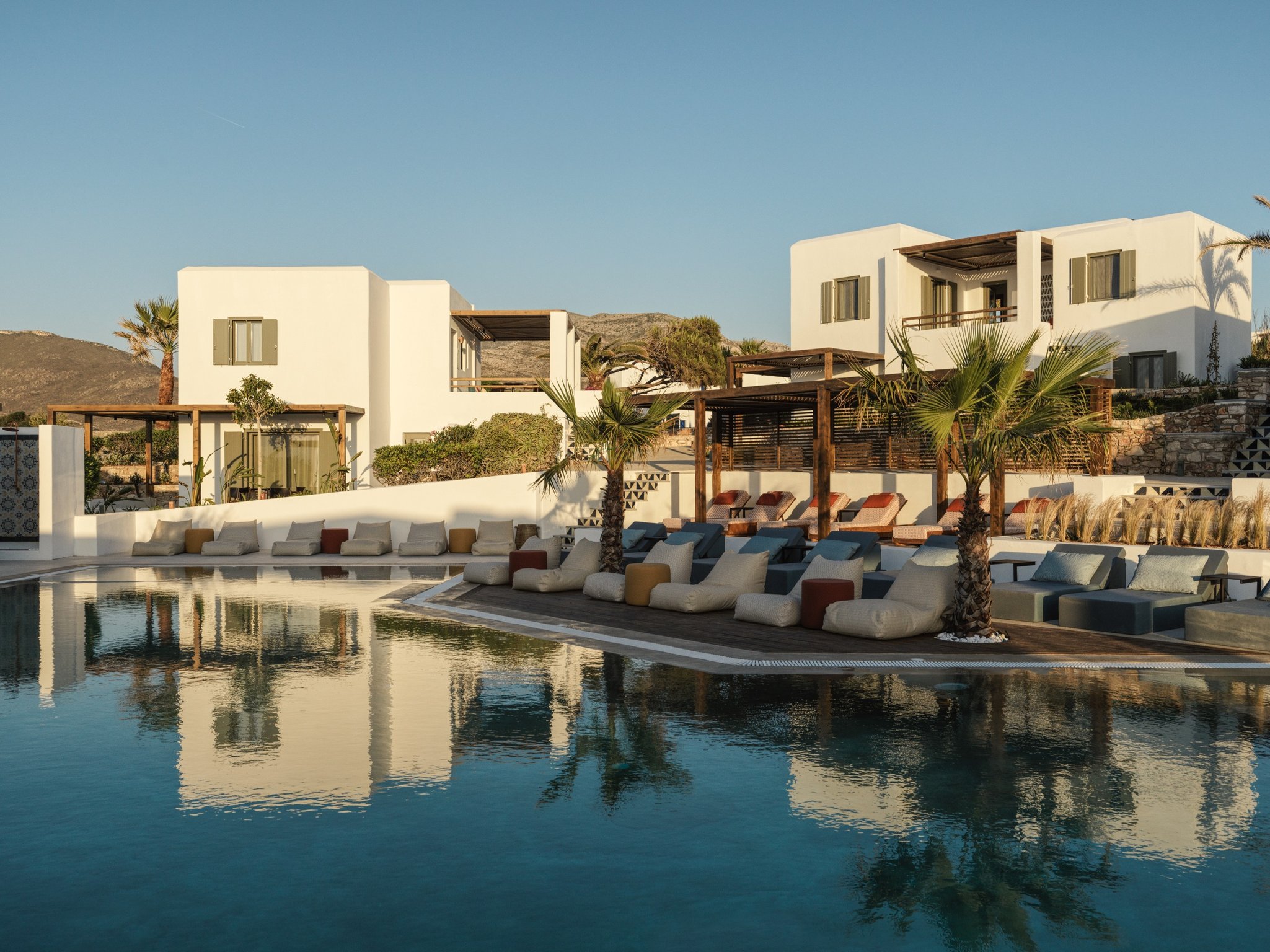 Greece’s Newest Luxury Hotel Is Located on the Untouched Cycladic Island of Paros | Andronis Minois cabanas by the pool | Andronis Minois restaurant at dusk | Andronis Minois suite kitchen | Andronis Minois outdoor pool | Andronis Minois outdoor dining | Andronis Minois bedroom suite