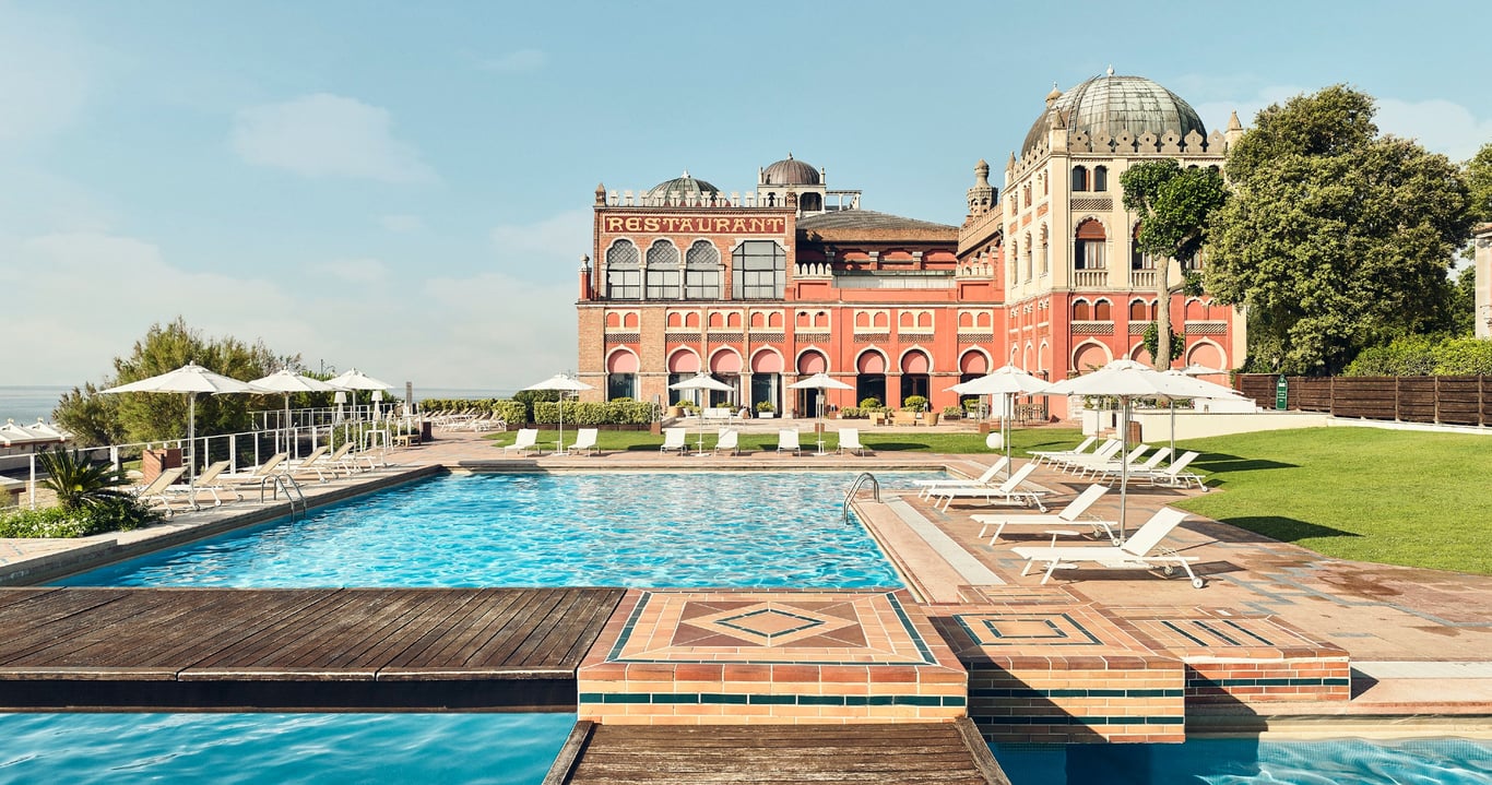 This Iconic Hotel Is The Home to the Famed Venice Film Festival | Hotel Excelsior at Venice Lido Resort exterior | Hotel Excelsior at Venice Lido Resort bedroom | Hotel Excelsior at Venice Lido Resort suite seating | Hotel Excelsior at Venice Lido Resort room entrance