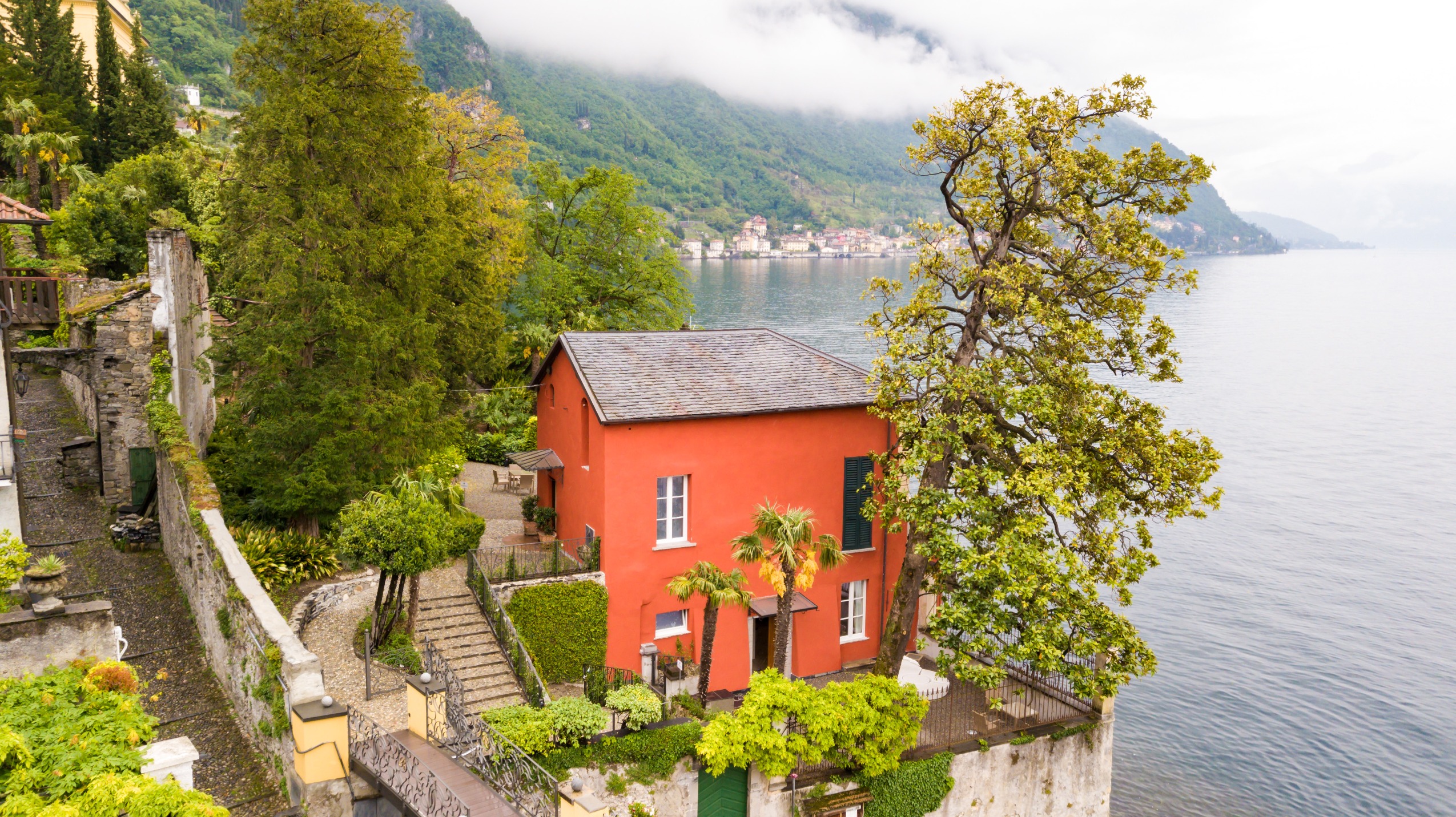 This Historic Villa in Lake Como Offers Some of the Best Views in Italy | Hotel Villa Cipressi exterior | Hotel Villa Cipressi exposed brick floor in suite | Hotel Villa Cipressi bedroom suite | Hotel Villa Cipressi outdoor fountain | Hotel Villa Cipressi lobby floor | Hotel Villa Cipressi suite balcony | Hotel Villa Cipressi Ocean entrance