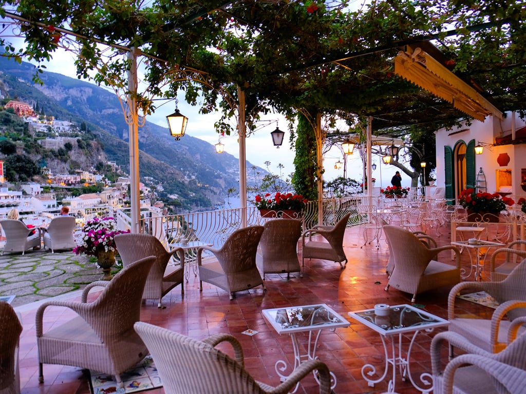 This Family-Owned Boutique Hotel in Positano Checks All the Boxes | Hotel Poseidon Positano aerial view | Hotel Poseidon Positano bar | Hotel Poseidon Positano outdoor pool | Hotel Poseidon Positano 1971-Vintage-VW-Beetle | Hotel Poseidon Positano Superior-Suite-Terrace | Hotel Poseidon Positano Liliana-Suite staircase | Hotel Poseidon Positano Superior-Suite-Living-Room