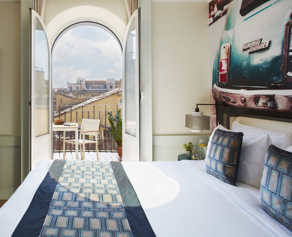This Boutique Hotel is Located on Rome's Most Quaint Cobblestone Street | Hotel Indigo Rome exterior | Hotel Indigo Rome bedroom | Hotel Indigo Rome rooftop seating | Hotel Indigo Rome bedroom balcony