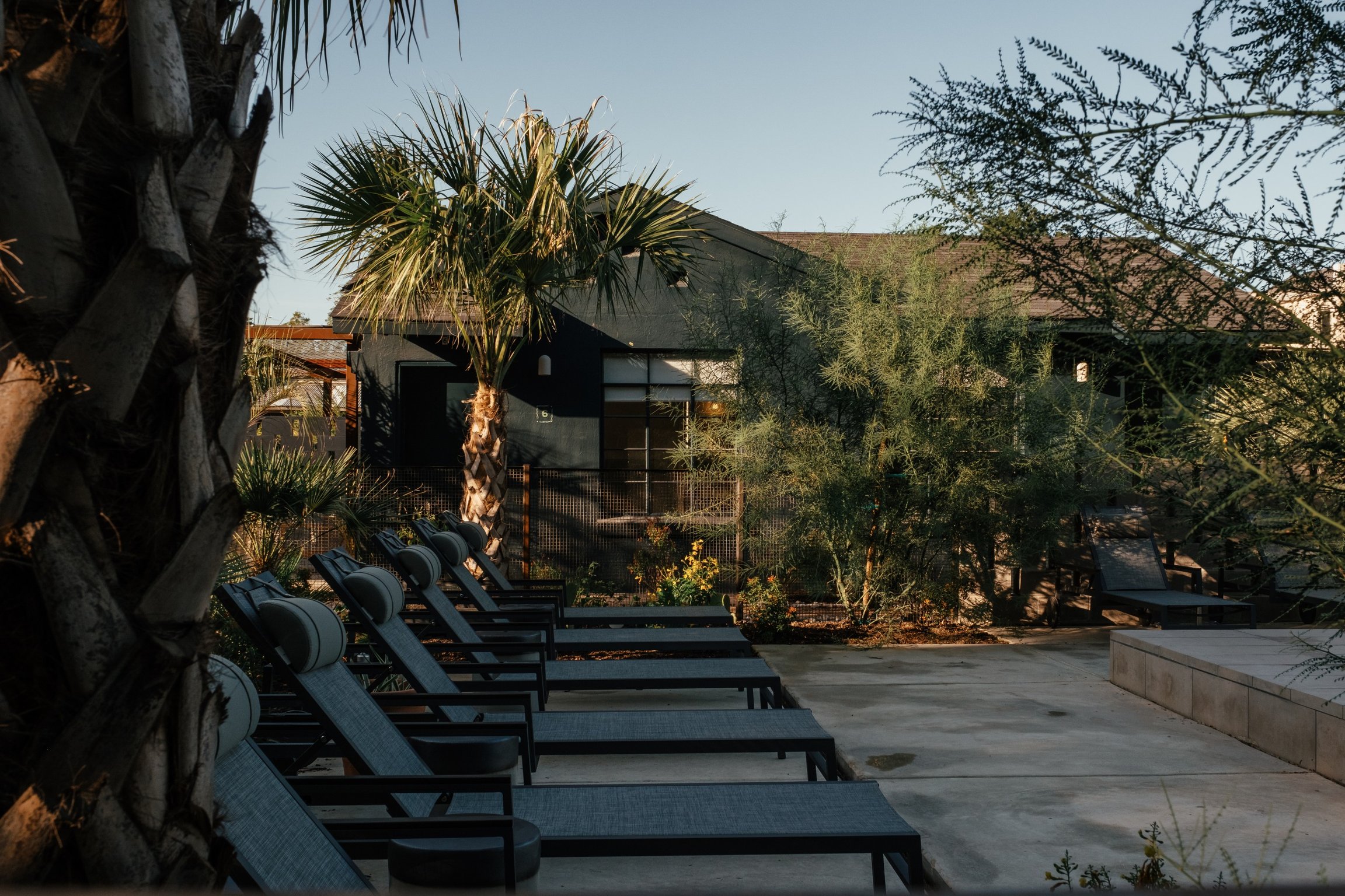 What’s Old Is New Again At this Re-imagined 1940s Motel By Brackenridge Park | Ranch Motel & Leisure Club courtyard entrance | Ranch Motel & Leisure Club bedroom suite | Ranch Motel & Leisure Club desk in suite | Ranch Motel & Leisure Club lounge sign | Ranch Motel & Leisure Club outdoor pool | Ranch Motel & Leisure Club outdoor seating