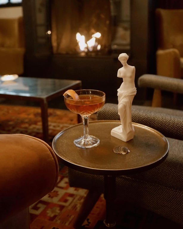 Meet NYC’s New Bar Concept for Queer Women, grotto | Grotto NYC women posing | Grotto restaurant and tables | Grotto woman silhouette with glass | Grotto orange drink bar