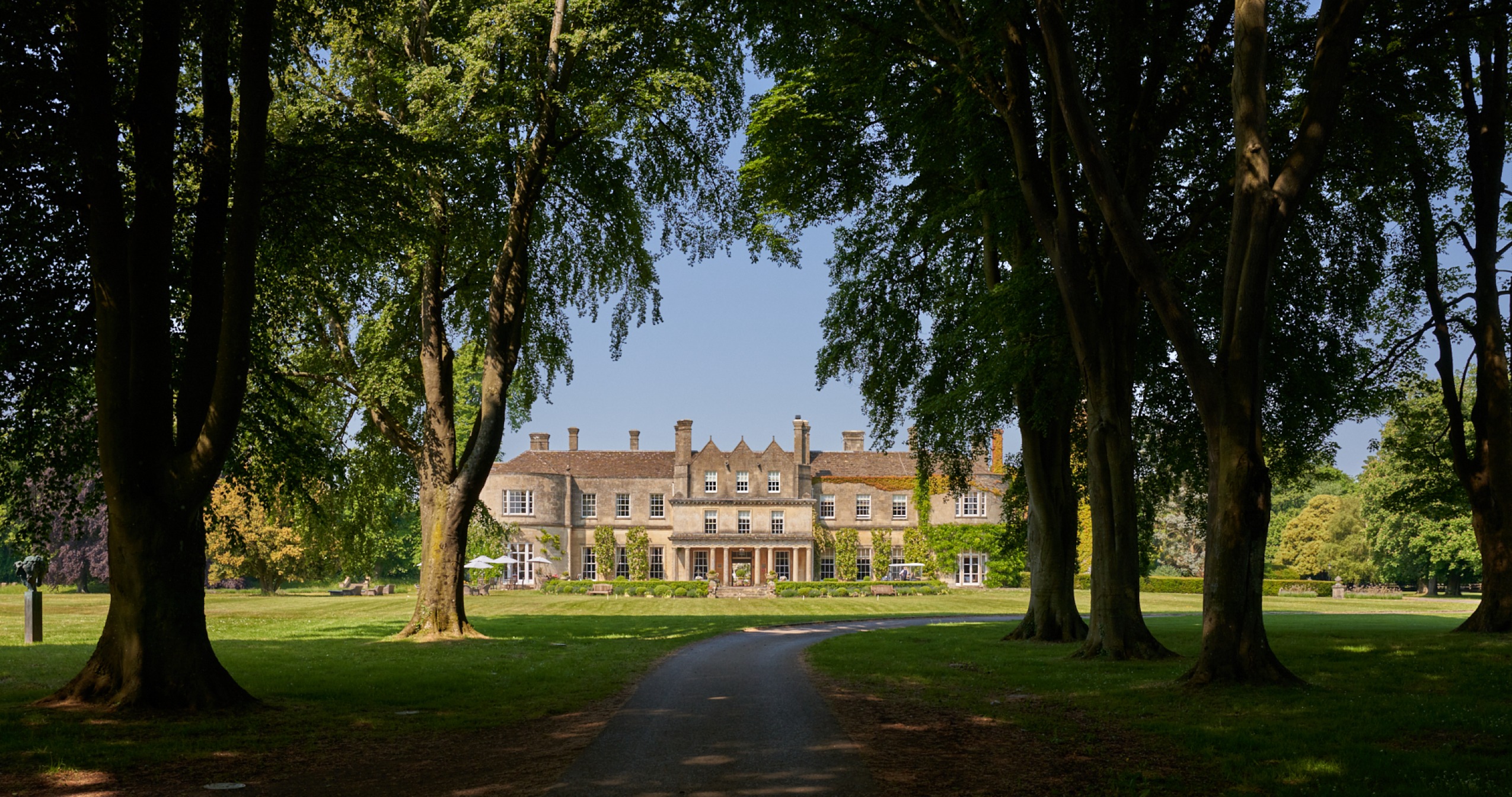 Lucknam Park Is the Originator of Country House Chic in England’s Wiltshire | Lucknam Park facade | Lucknam Park open doors | Lucknam Park bedroom suite | Lucknam Park indoor pool | Lucknam Park dinner plate | Lucknam Park entrance