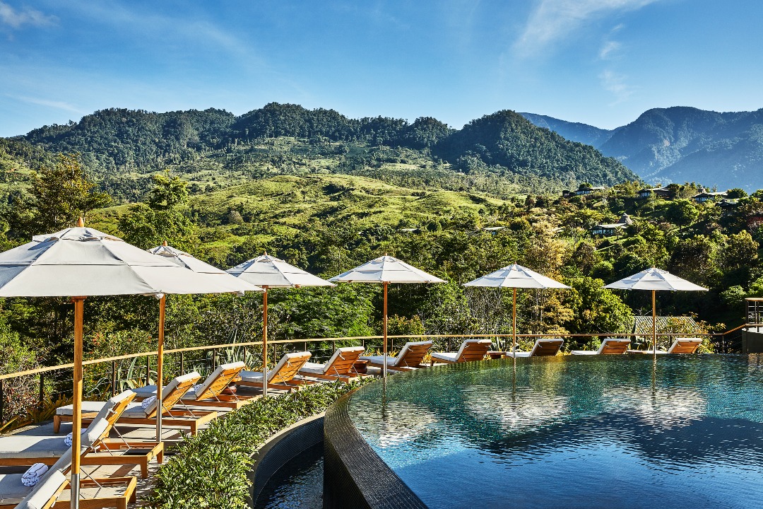 This Costa Rican Rainforest Hotel Is Worth the Trek | Hacienda AltaGracia aerial view | Hacienda AltaGracia outdoor lounge | Hacienda AltaGracia outdoor seating | Hacienda AltaGracia cabana seating | Hacienda AltaGracia cabana poolsode seating | Hacienda AltaGracia restaurant | Hacienda AltaGracia outdoor walkways | Hacienda AltaGracia greenhouse | Hacienda AltaGracia outdoor pool