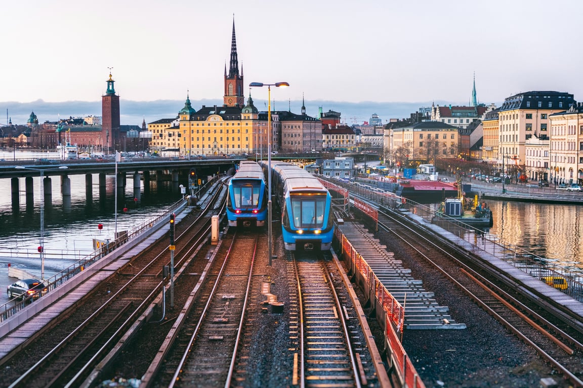 How to Take Advantage of Eurail: The Easiest Way to Travel Through Europe This Summer | Eurail travelling near water | My Eurail pass card | Woman sitting on the Eurail | Eurail app | Two people holding up passports | Man in hat drinking coffee in Eurail