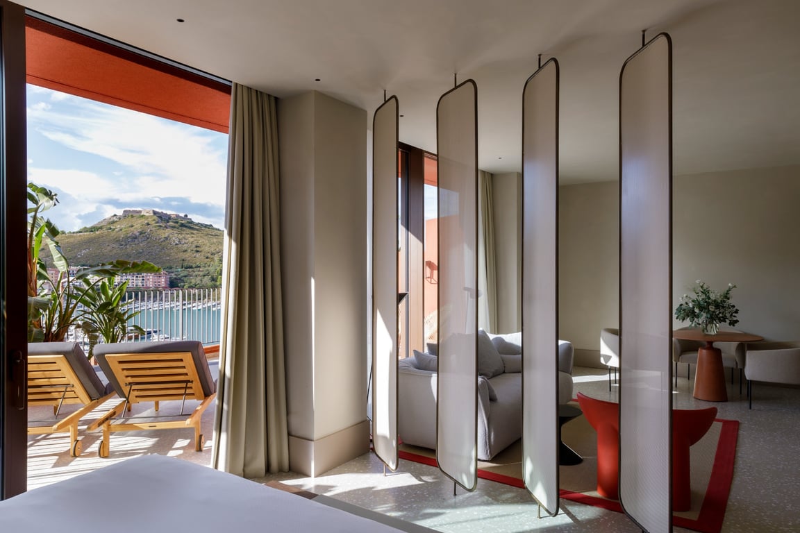 La Roqqa is the Newest Design-Forward Charmer Off of Italy’s Tuscan Coast | La Roqqa exterior and balcony | Tuscany aerial view | La Roqqa outdoor dining by the water | La Roqqa arched walkway | La Roqqa aerial view | La Roqqa bedroom suite | La Roqqa rooftop