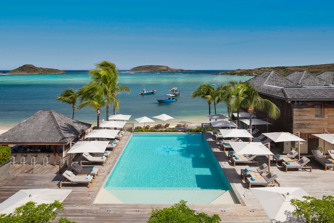 This Luxury Hotel in St. Barth Feels Both Like Home and a Lavish Retreat | Le Barthélemy Hotel & Spa outdoor pool | Le Barthélemy Hotel & Spa aerial view | Le Barthélemy Hotel & Spa bedroom suite | Le Barthélemy Hotel & Spa sunbathing | Le Barthélemy spa | Le Barthélemy Hotel & Spa restaurant