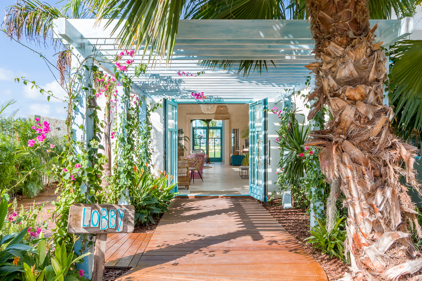 This Soothing Boutique Hotel in Aruba Combines Tropical Charm and Intimate Service | The Boardwalk Hotel Aruba exterior | The Boardwalk Hotel Aruba walkway | The Boardwalk Hotel Aruba pool | The Boardwalk Hotel Aruba restaurant