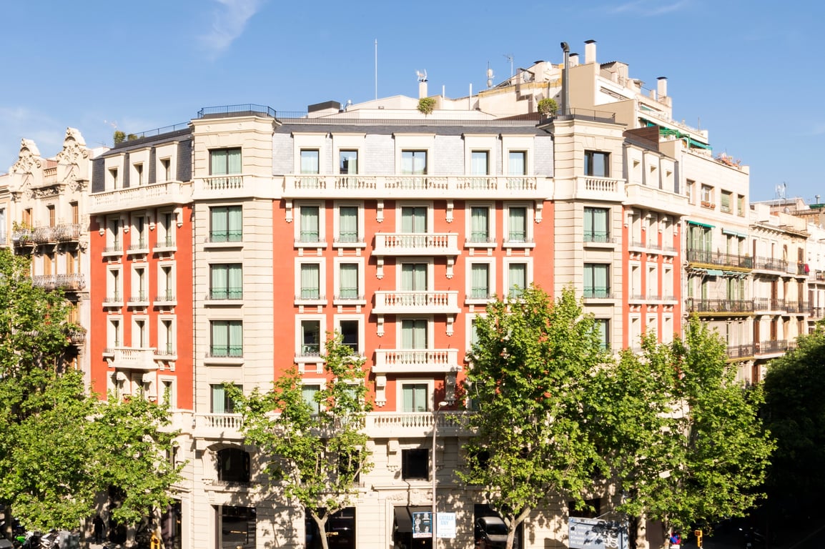 Discover The Most Charming Hotel in Barcelona’s Storied Eixample District | The Corner Hotel exterior | The Corner Hotel lobby | The Corner Hotel bedroom suite | The Corner Hotel rooftop pool