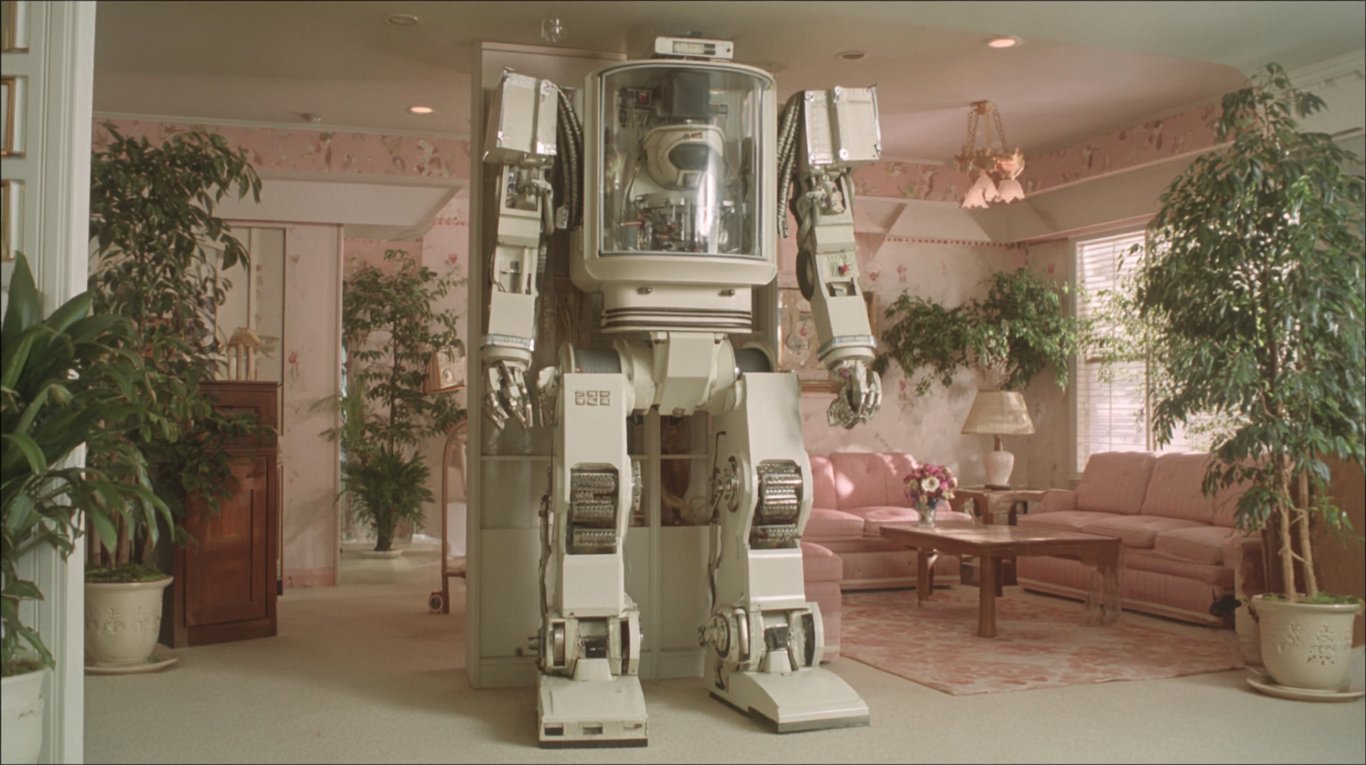 A translucent mechanical exoskeleton standing upright in an empty workshop, light passing through the hollow space where a body should be, tools arranged on the workbench behind it waiting for hands that are not there