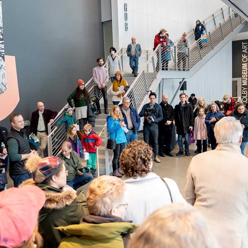 Attendees gather around the grand staircase to hear remarks before a ribbon cutting to mark the opening of the Paul J. Schupf Arts Center