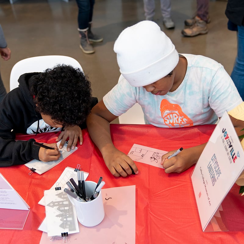 Community members participate in making cityscape lanterns during Joy to the Ville at the opening of the Paul J. Schupf Arts Center