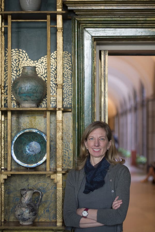 Headshot of Lee Glazer standing inferno of a hallway and beside three vases.